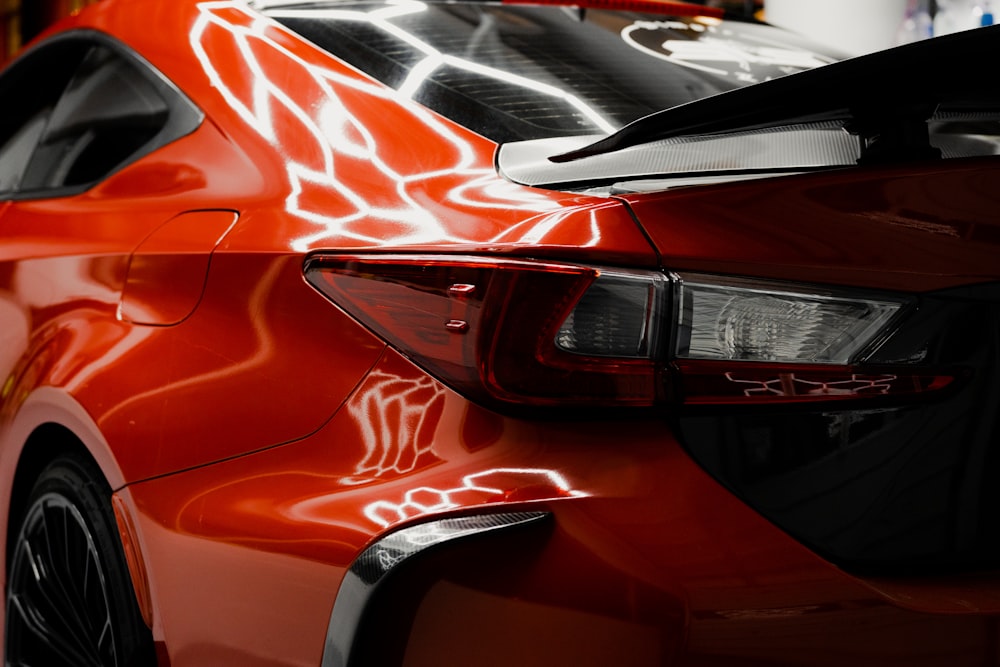 a close up of a red car parked in a garage