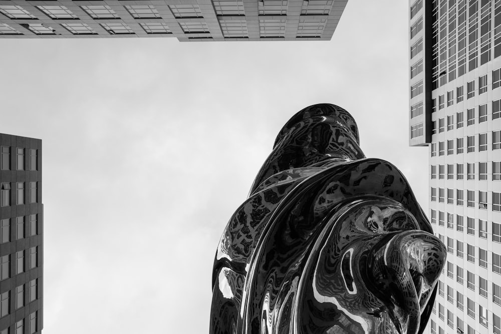 Una foto in bianco e nero di una statua nel mezzo di una città