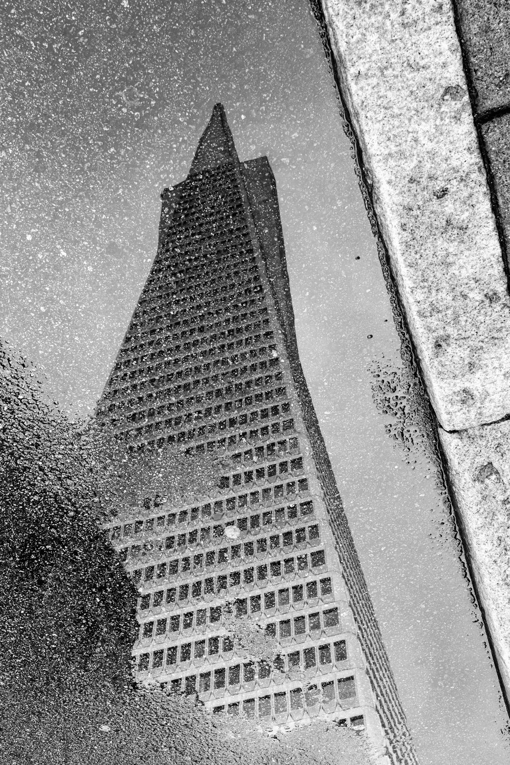 a reflection of a building in a puddle of water