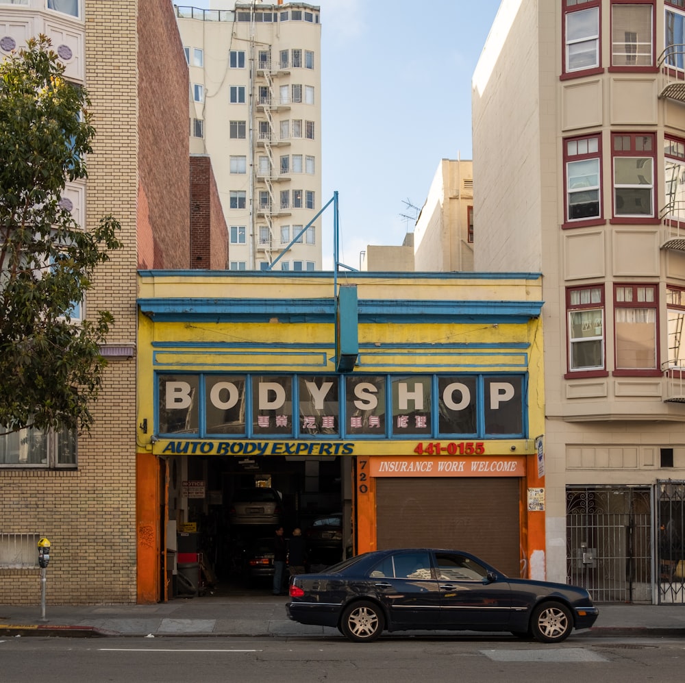 a car parked in front of a body shop