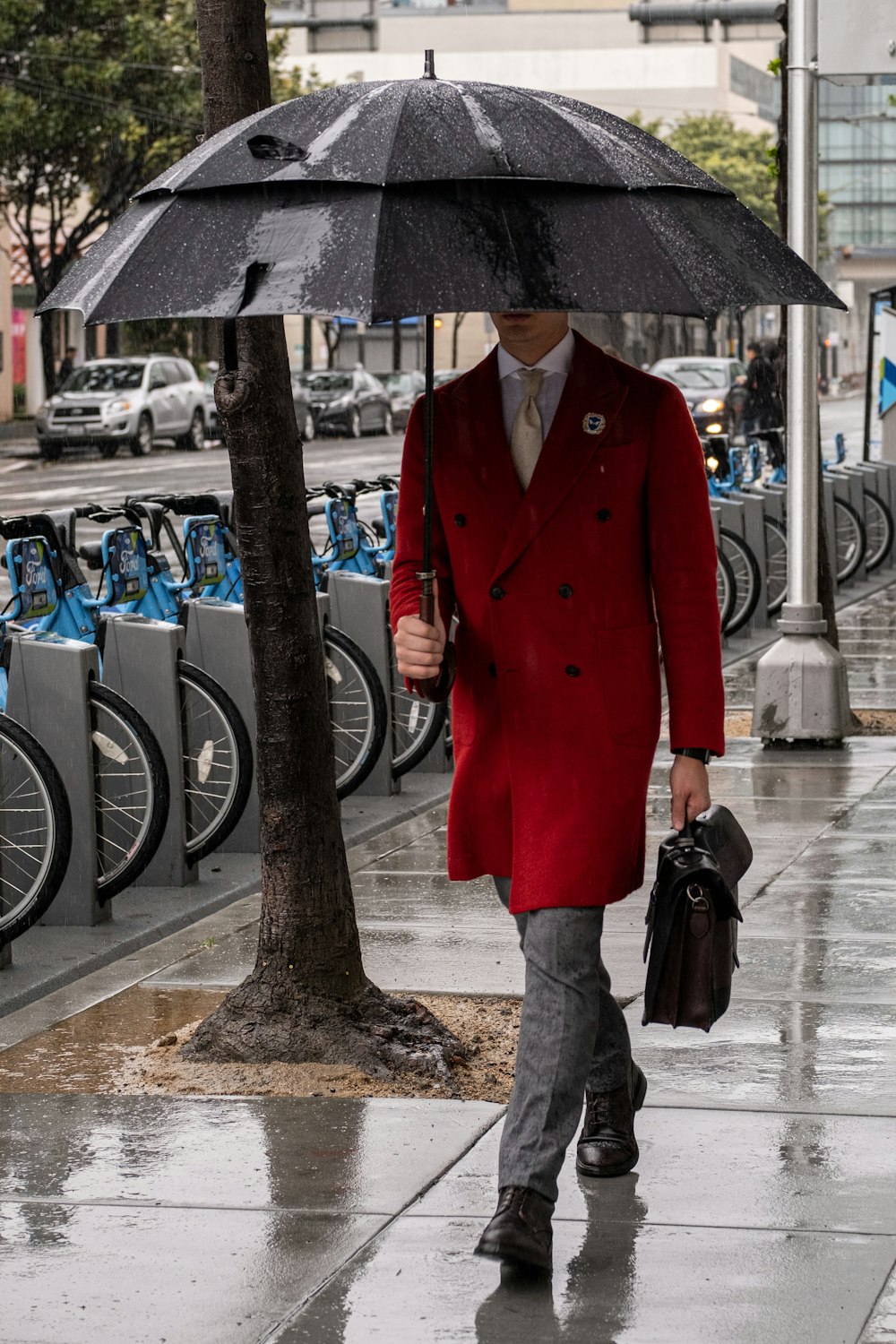 a man in a red coat holding an umbrella
