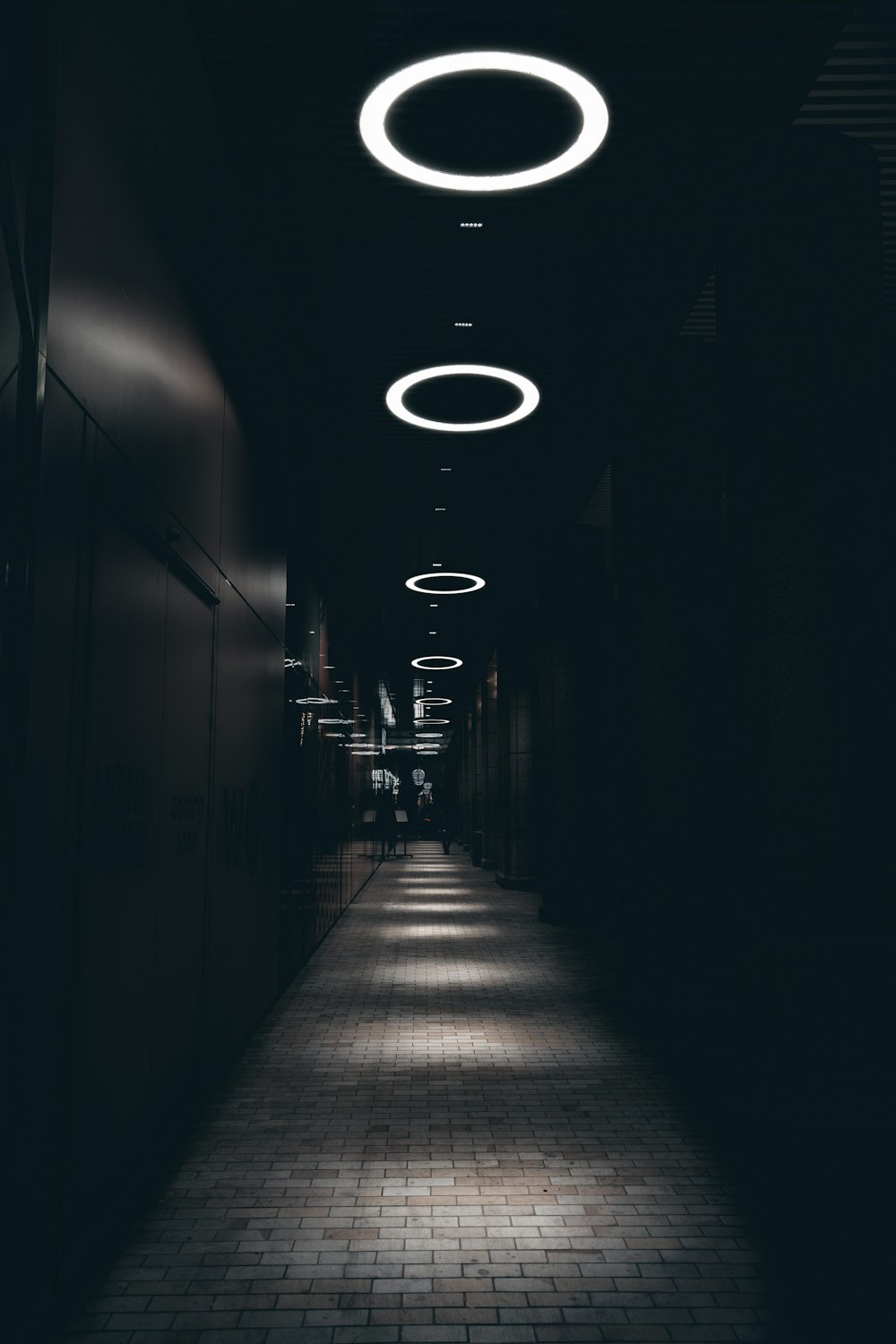 a long dark hallway with lights on the ceiling