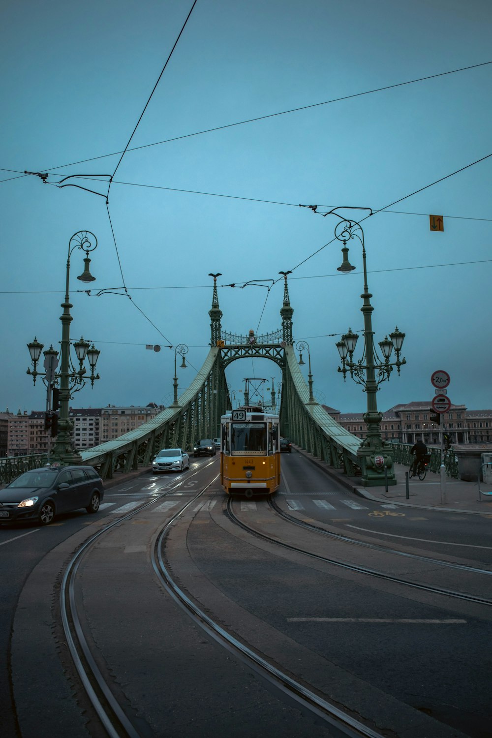 a yellow train traveling across a bridge over a street