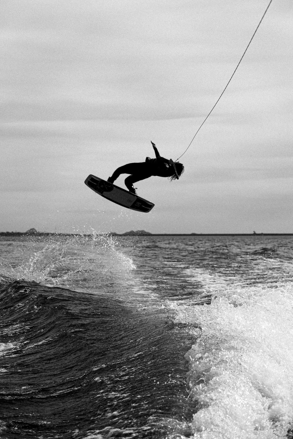 uma pessoa em uma prancha de surf no ar acima da água