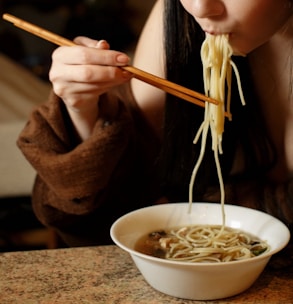 A busy professional enjoying a quick konjac noodle lunch at their desk.