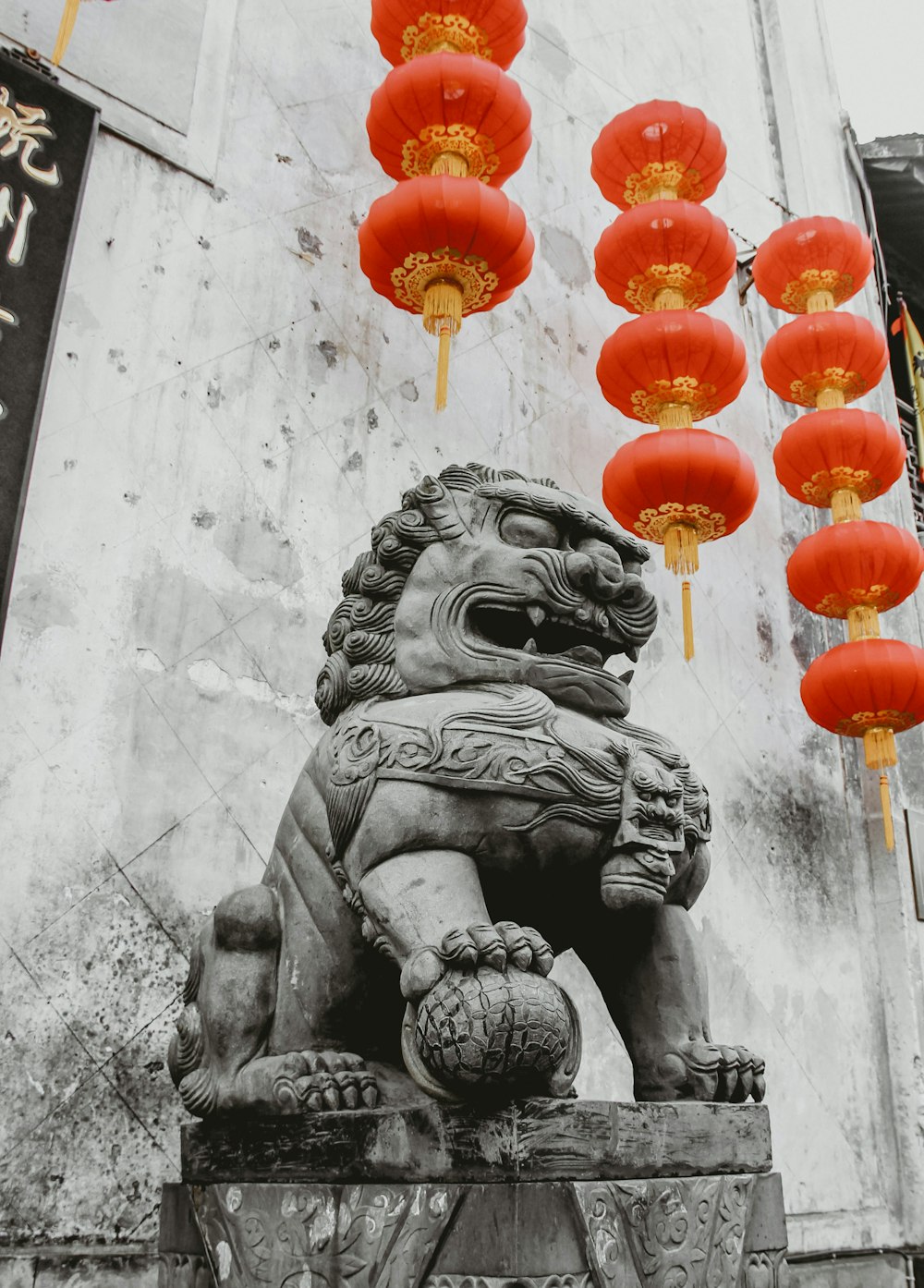une statue de lion entourée de lanternes rouges