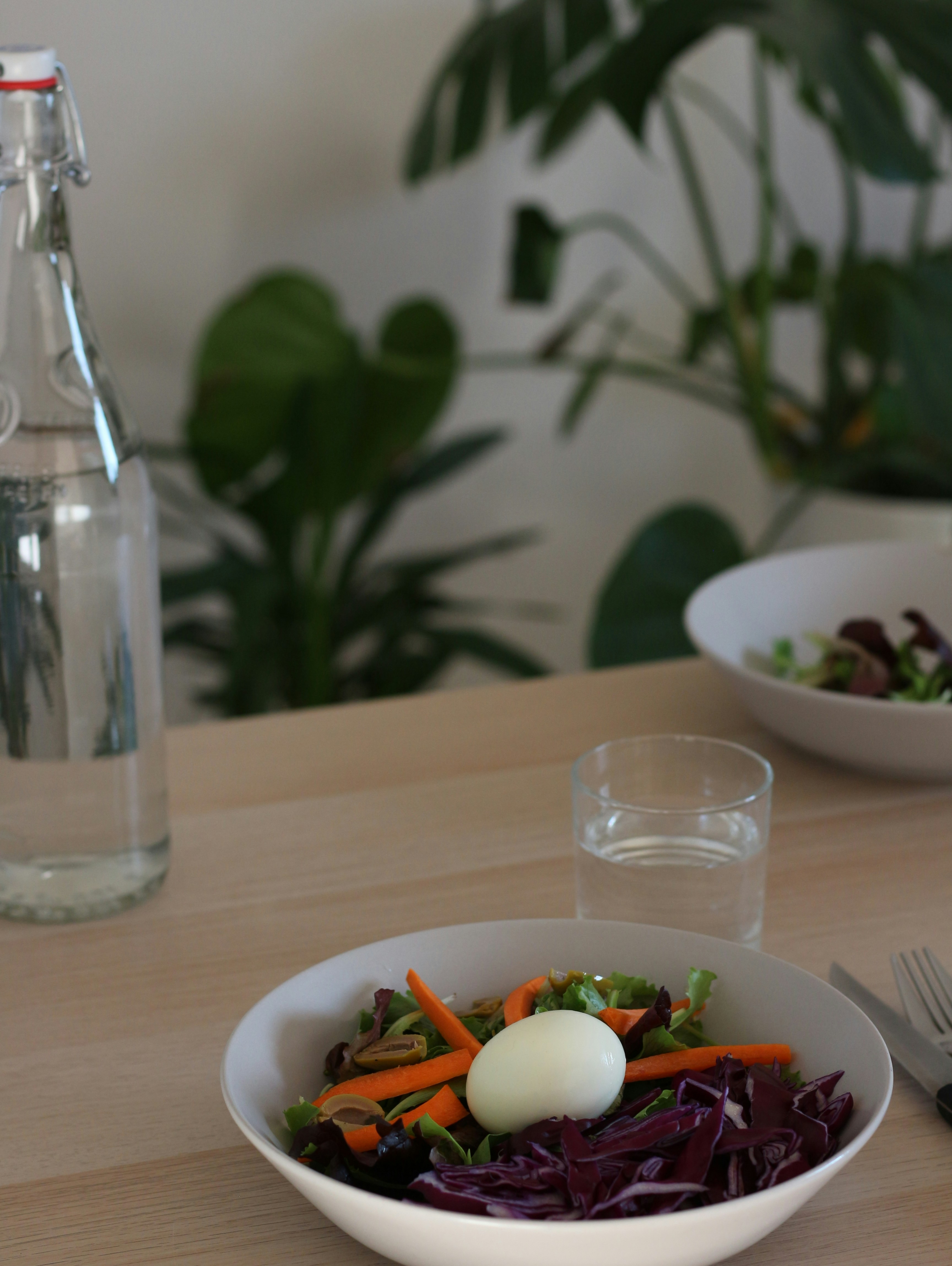 eine Schüssel Salat mit einem Ei darauf