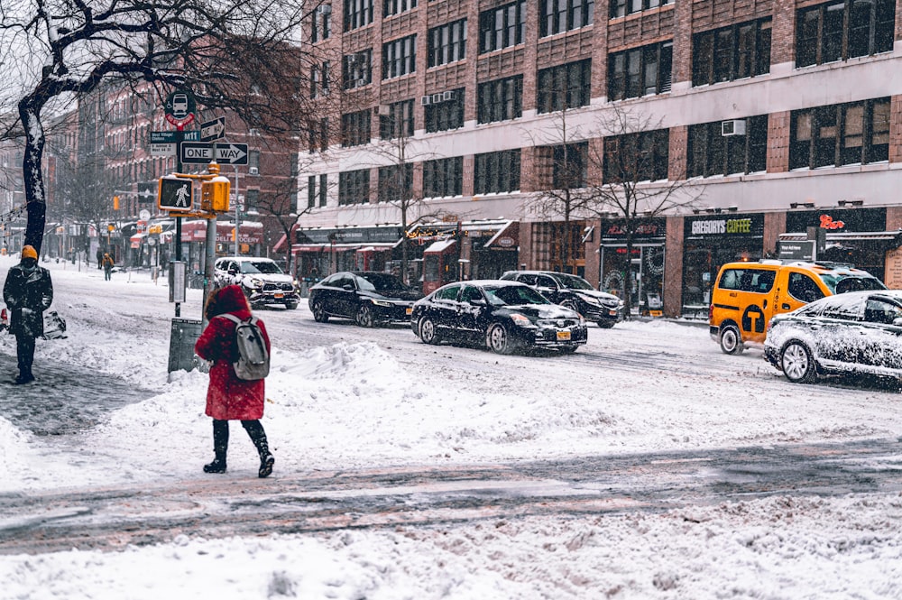 a woman walking across a snow covered street