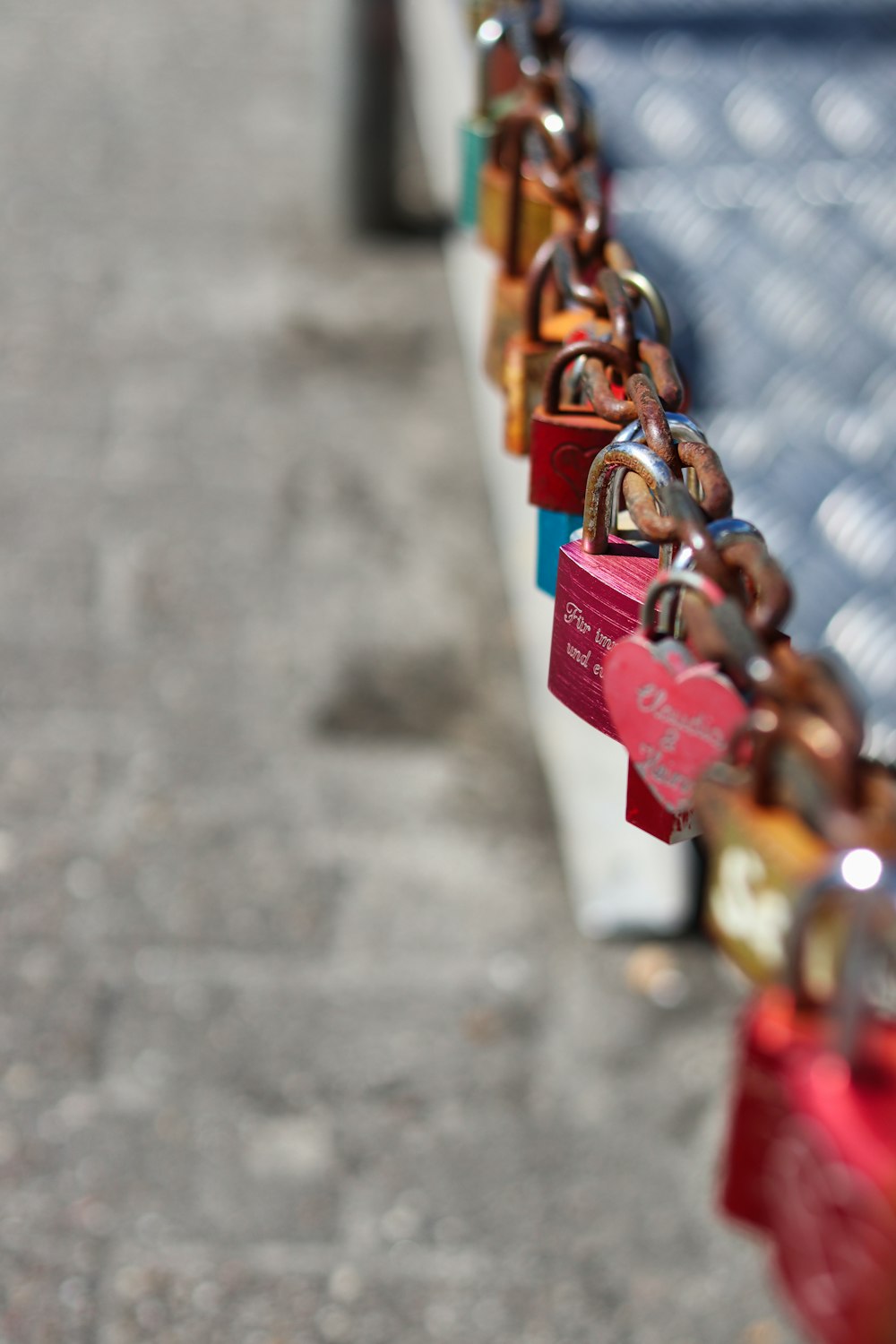a row of colorful padlocks attached to a white bench