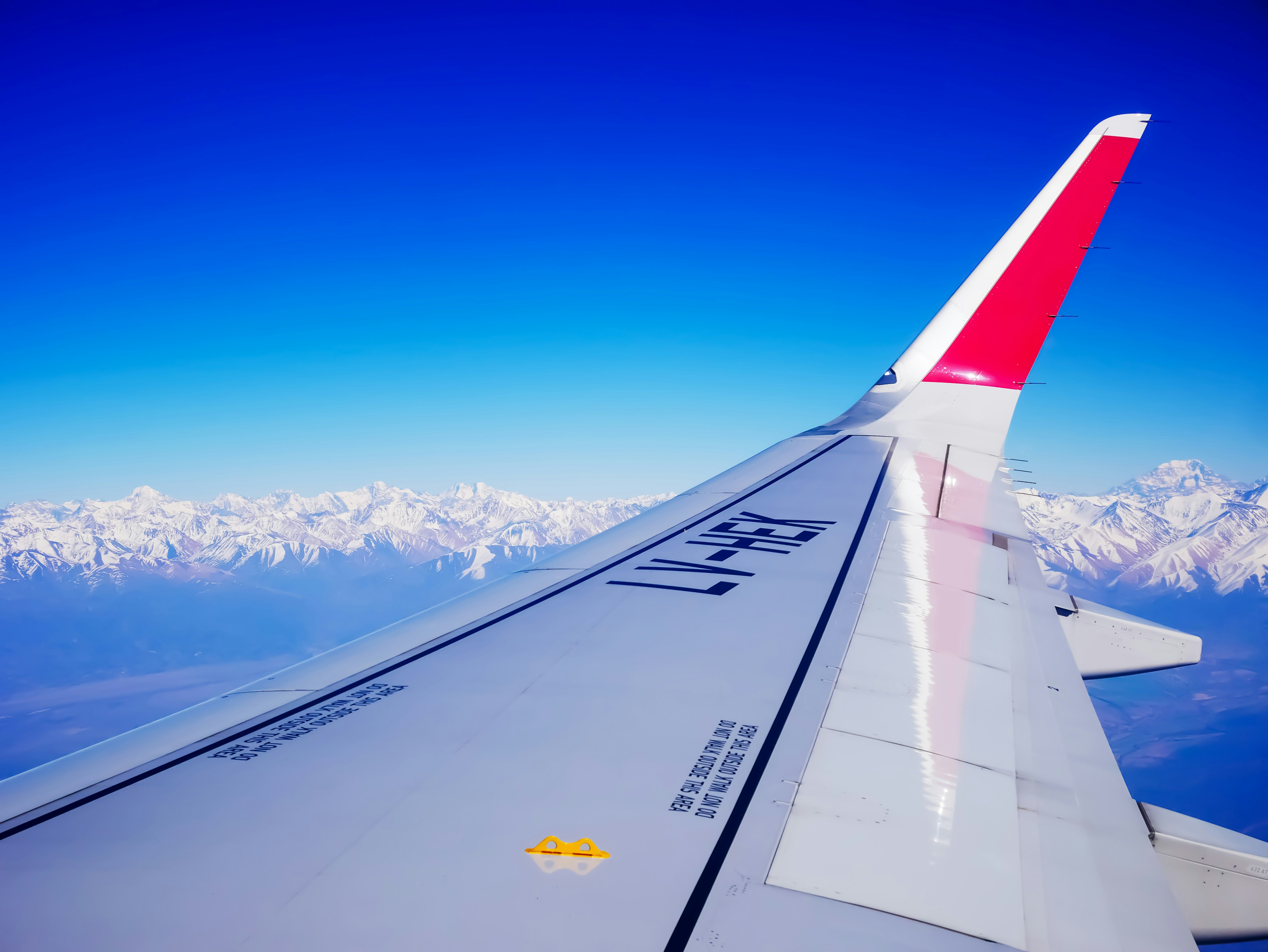 The wing of an airplane while flying through The Andes Mountains