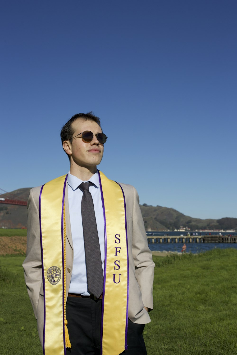 a man in a suit and tie standing in a field