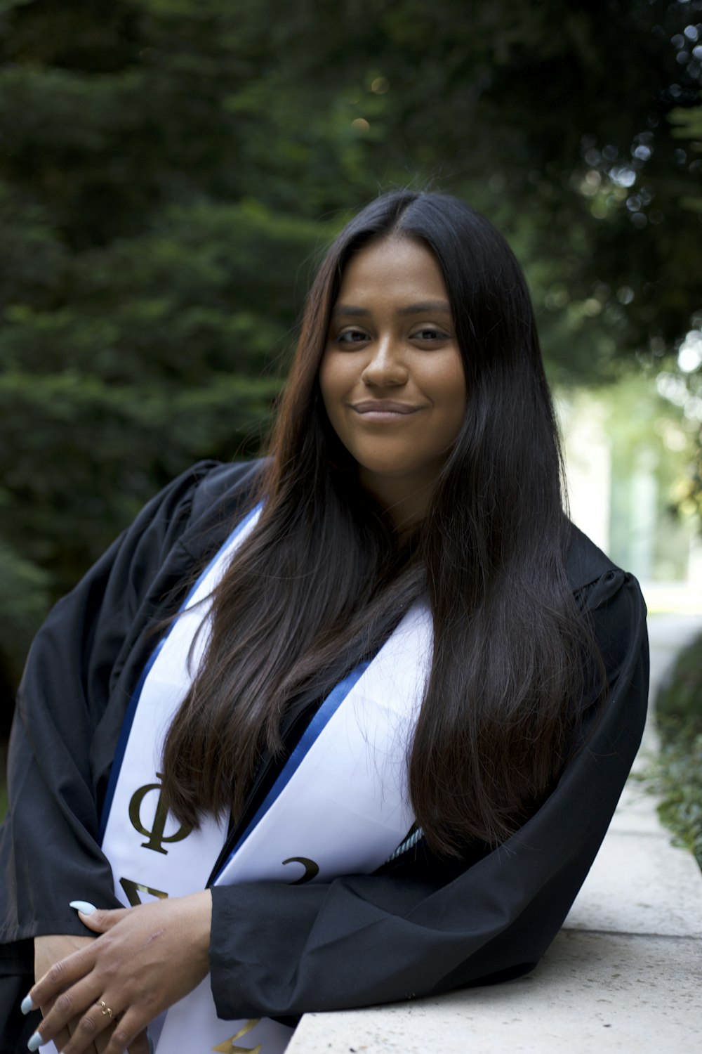 Una donna in un abito di laurea in posa per una foto