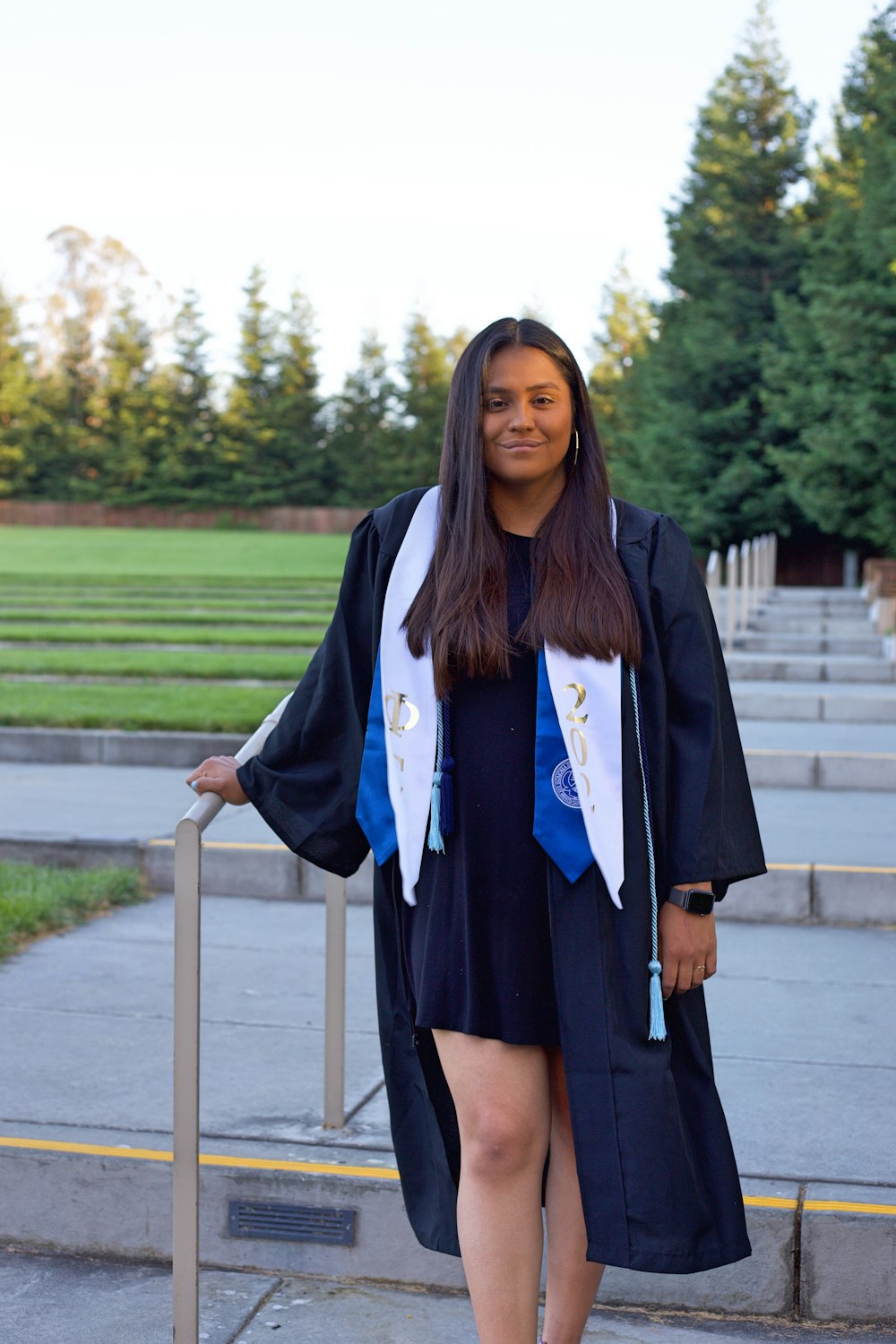 a woman in a graduation gown standing on steps