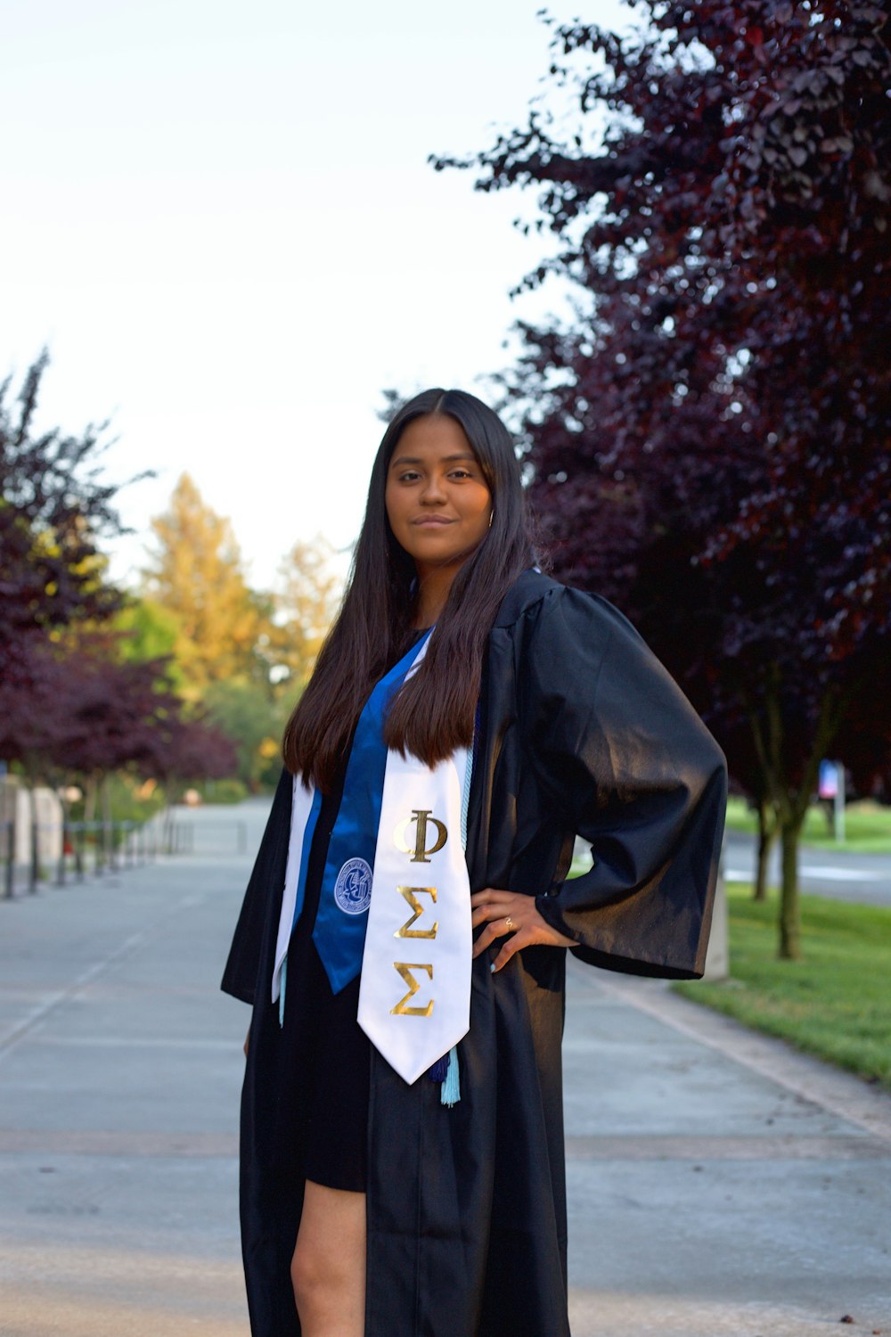 a woman in a graduation gown poses for a picture