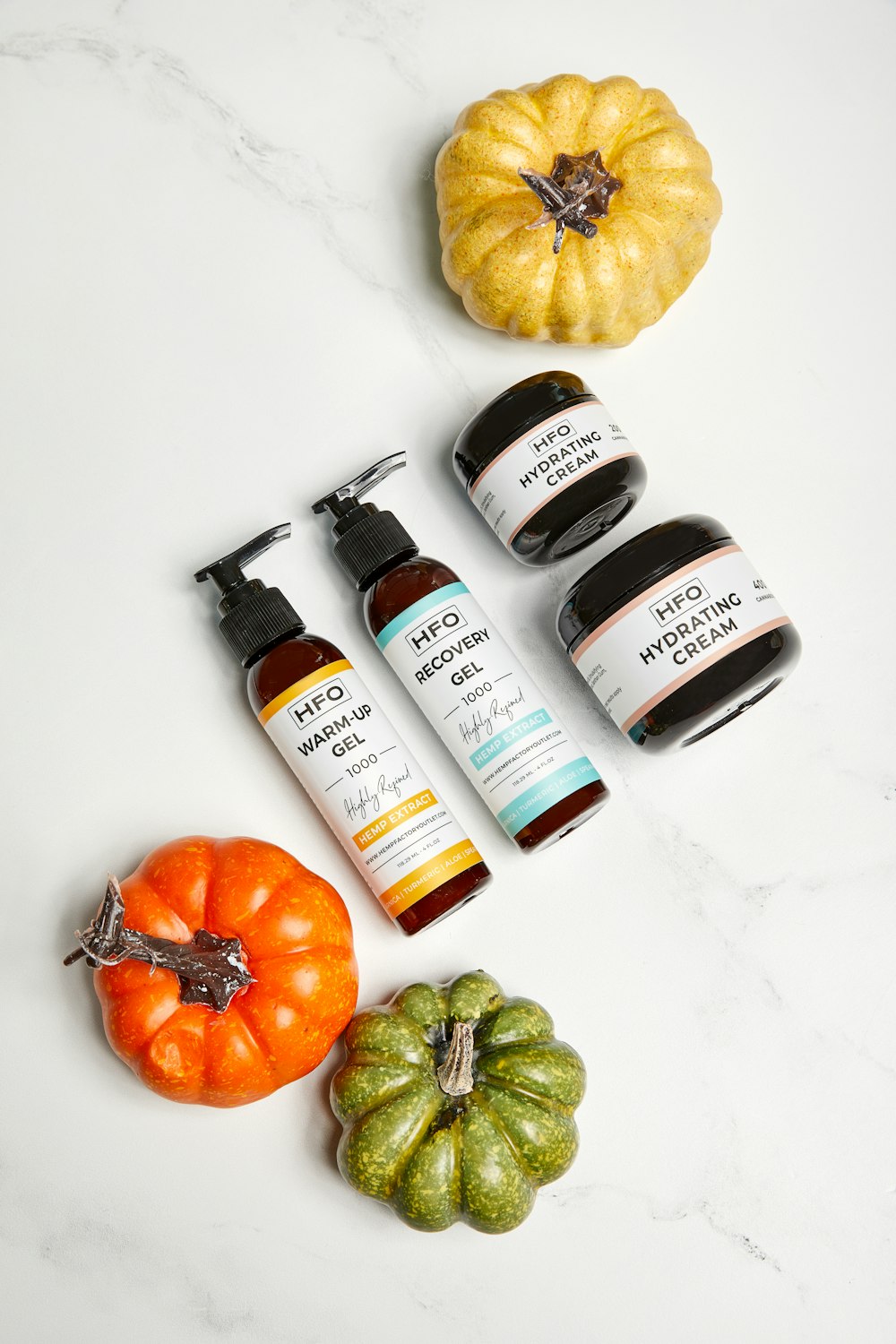 a table topped with bottles of skin care and pumpkins