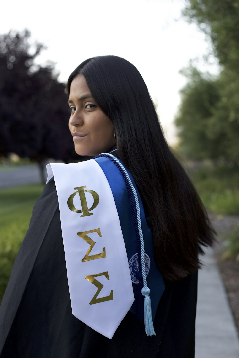 a woman wearing a graduation gown and a sash