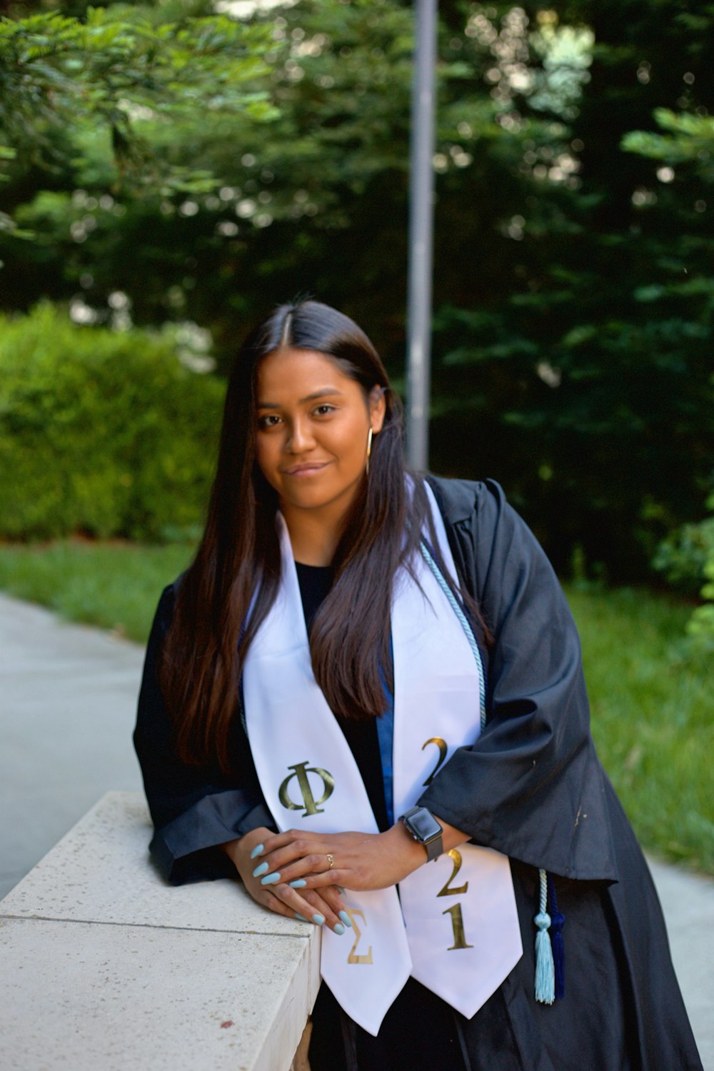 a woman in a graduation gown leaning on a wall