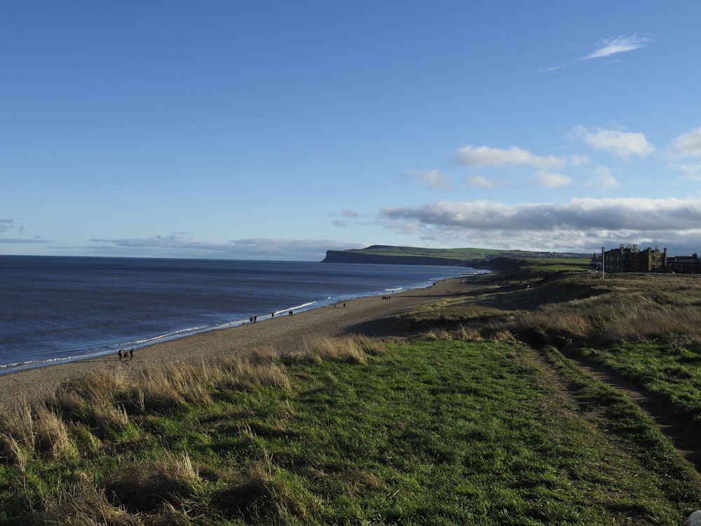 a view of a beach with people walking on it