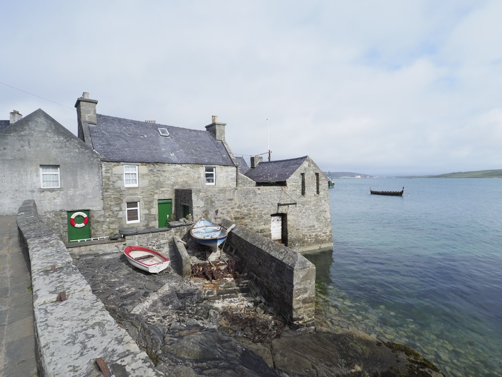 a boat is parked on the shore of a small village