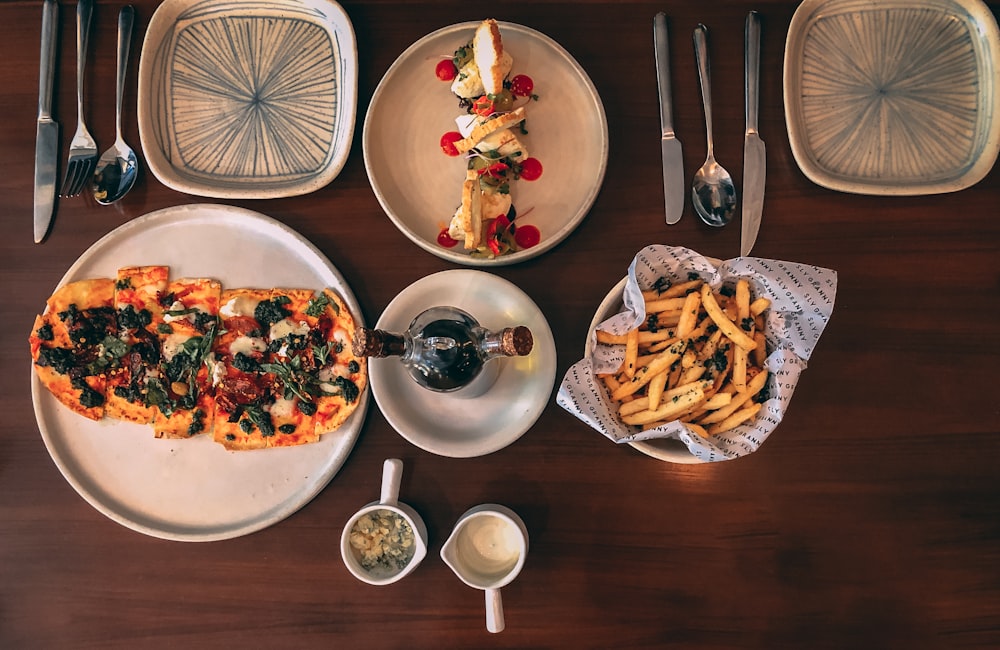 a wooden table topped with plates of food