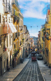 a train traveling down a street next to tall buildings