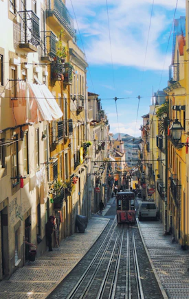 a train traveling down a street next to tall buildings
