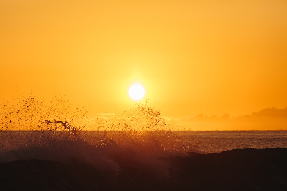 a person riding a surfboard on a wave at sunset