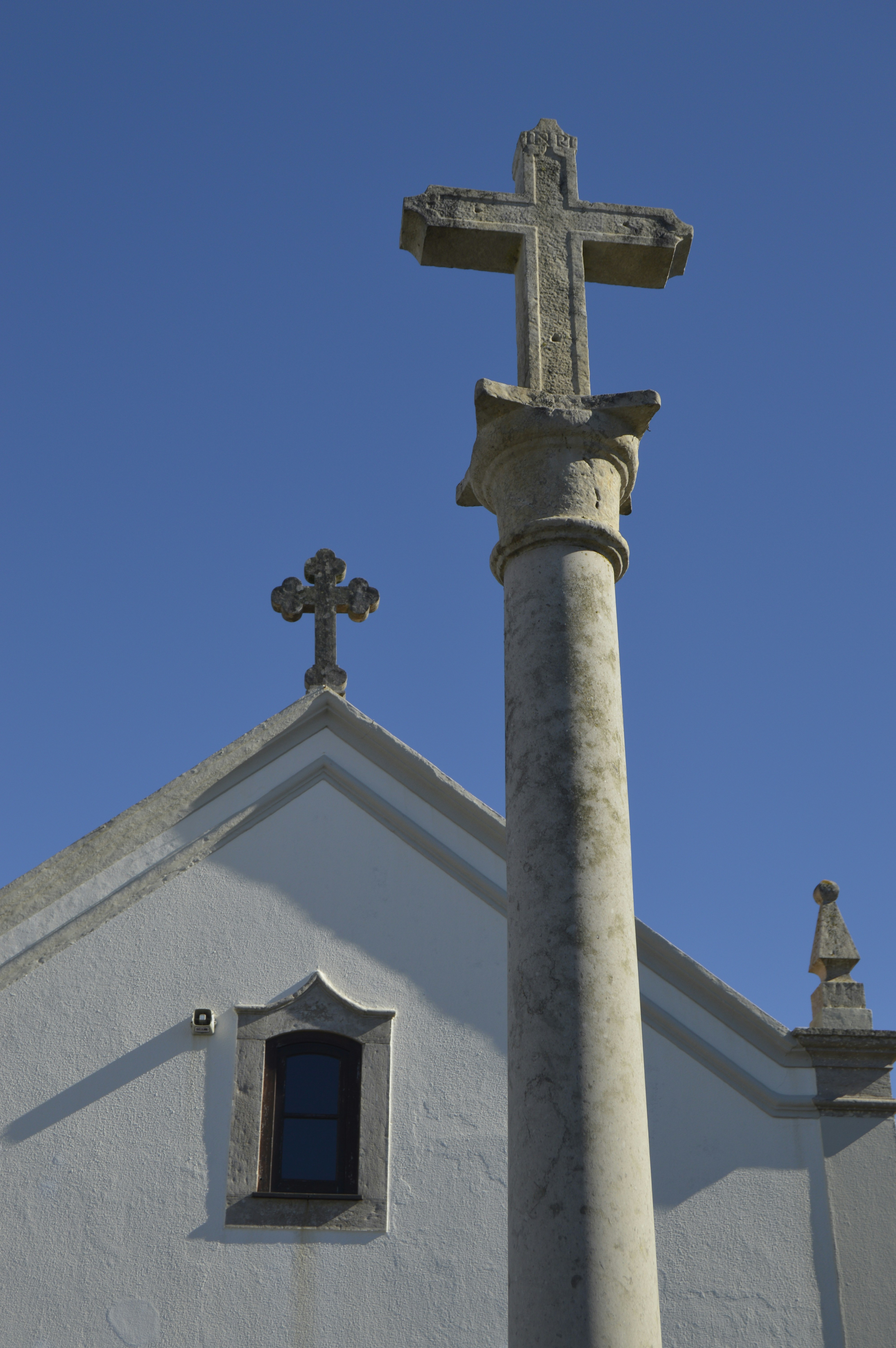 a cross on top of a building with a window
