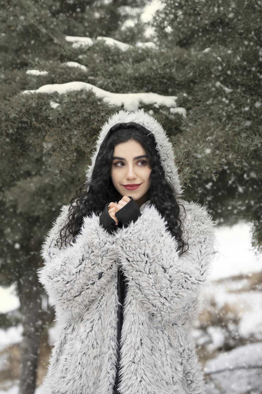 a woman in a fur coat standing in the snow