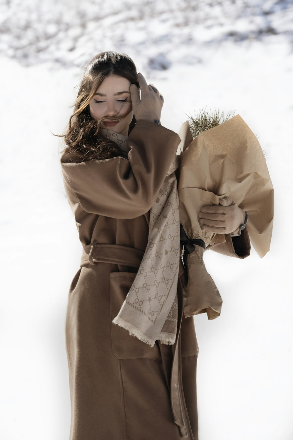 a woman walking in the snow talking on a cell phone