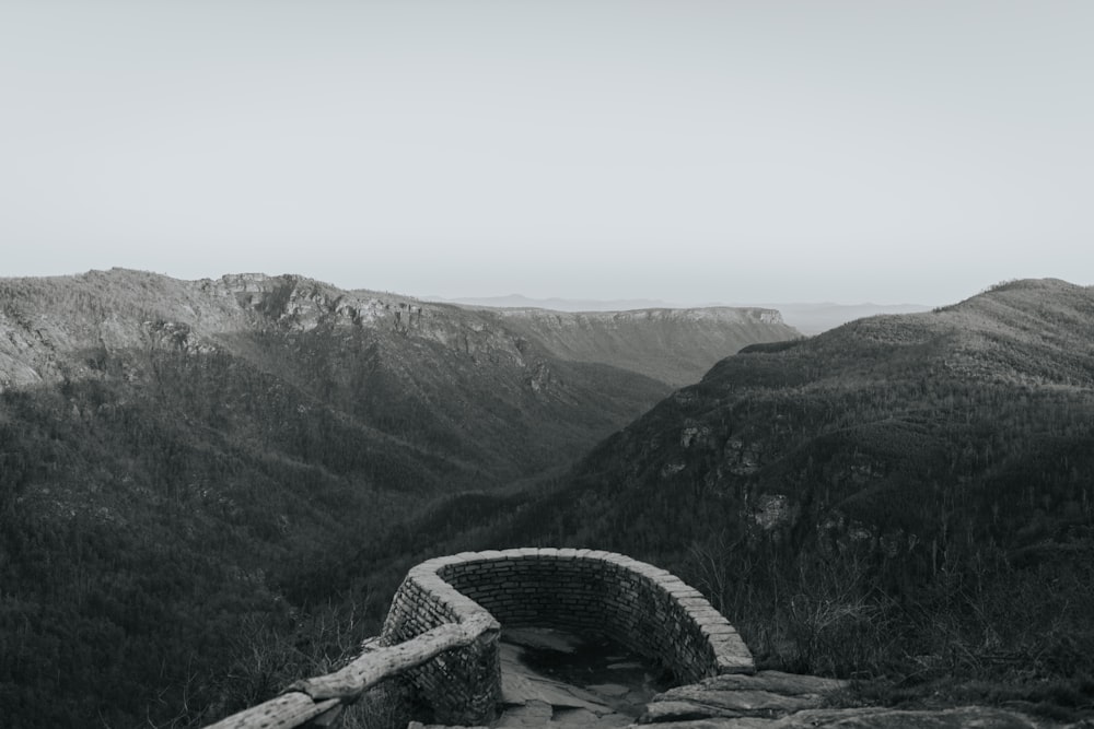 uma foto em preto e branco de uma ponte de pedra