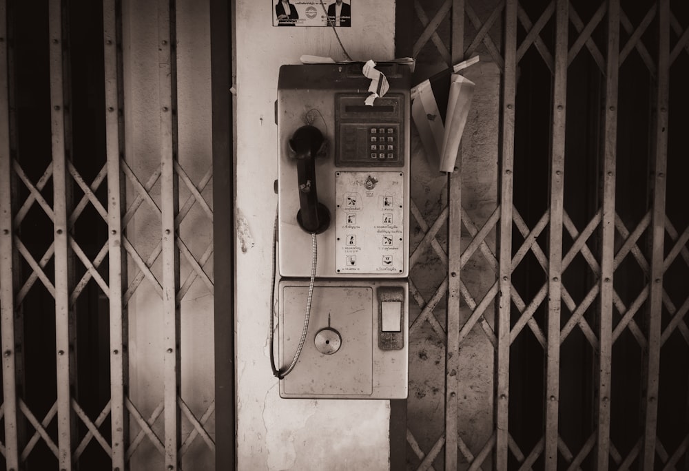an old phone is on the wall of a building