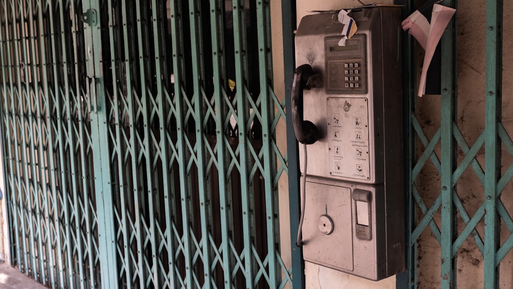 an old phone is attached to a fence