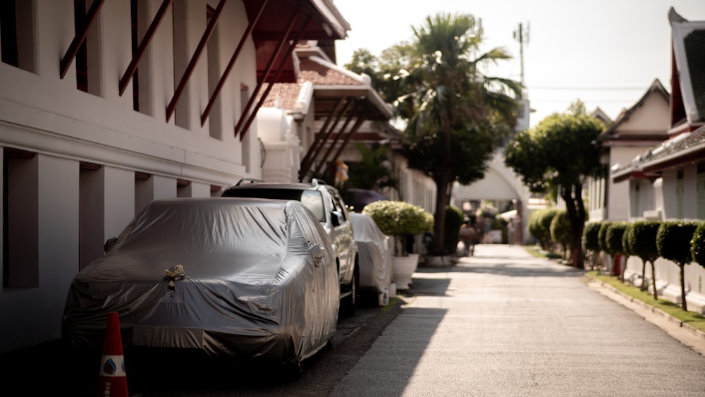 a car covered in a tarp parked on the side of a street