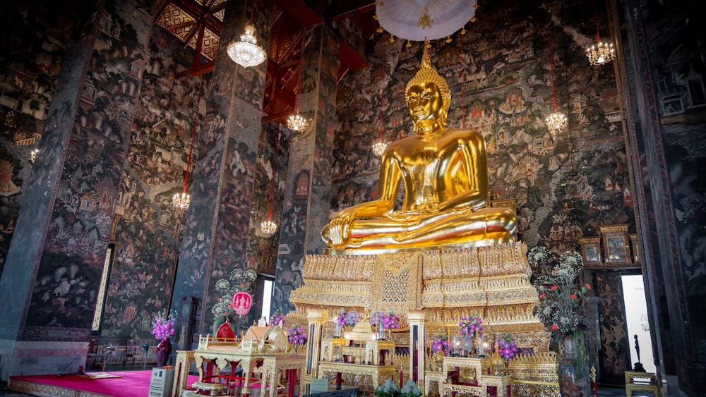 a large golden buddha statue sitting inside of a building