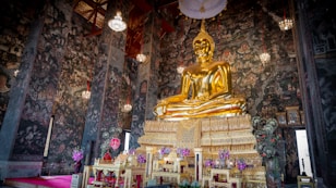 a large golden buddha statue sitting inside of a building