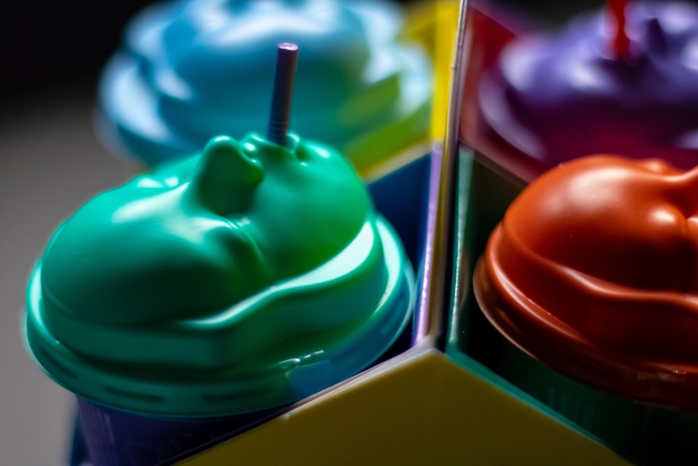 a close up of three different colored cups