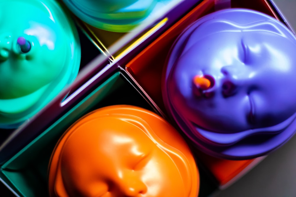 a box filled with different colored cupcakes on top of a table