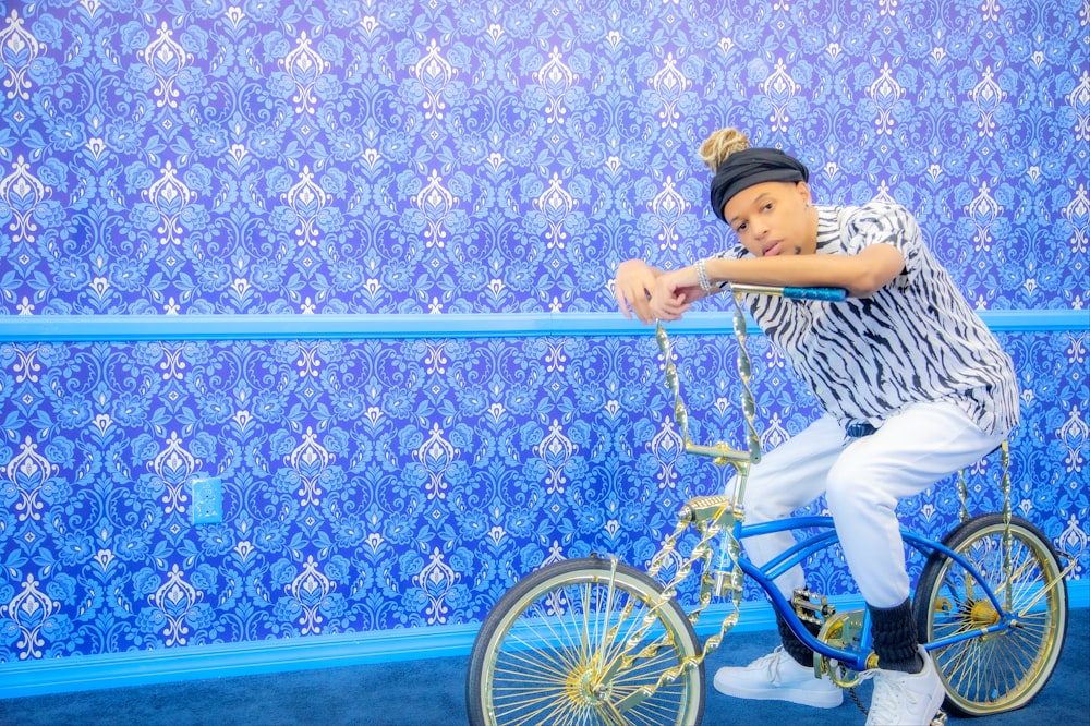 a person riding a bike in front of a blue wall