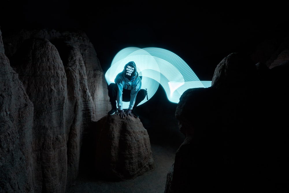 a person sitting on a rock in the dark