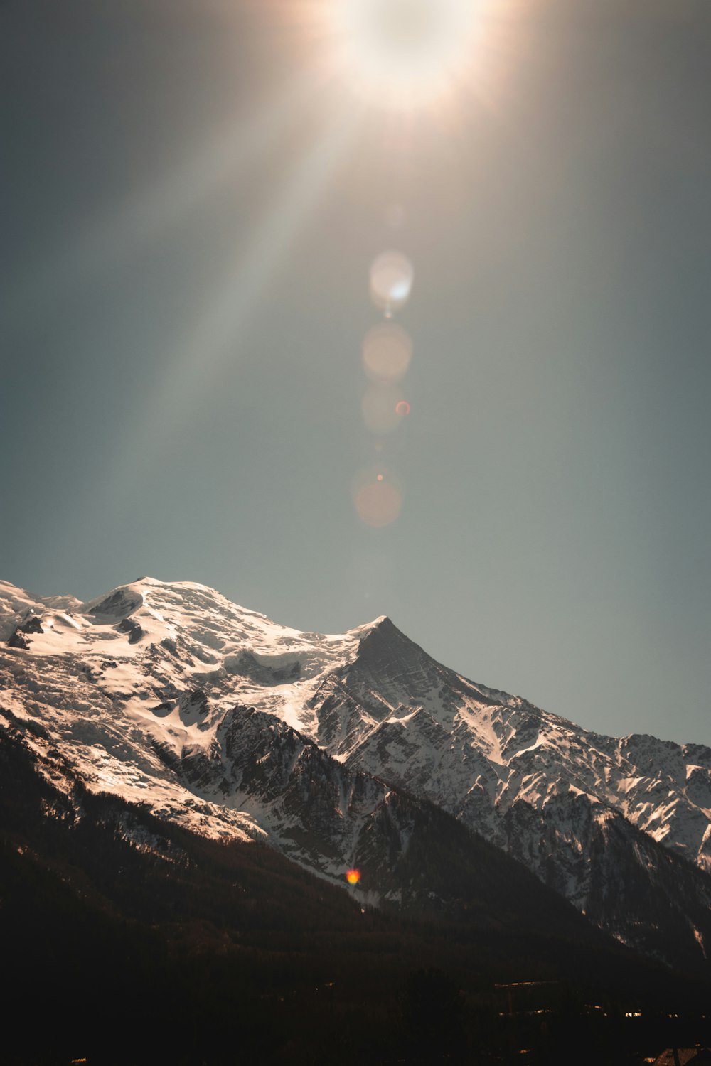 the sun shines brightly on a snowy mountain