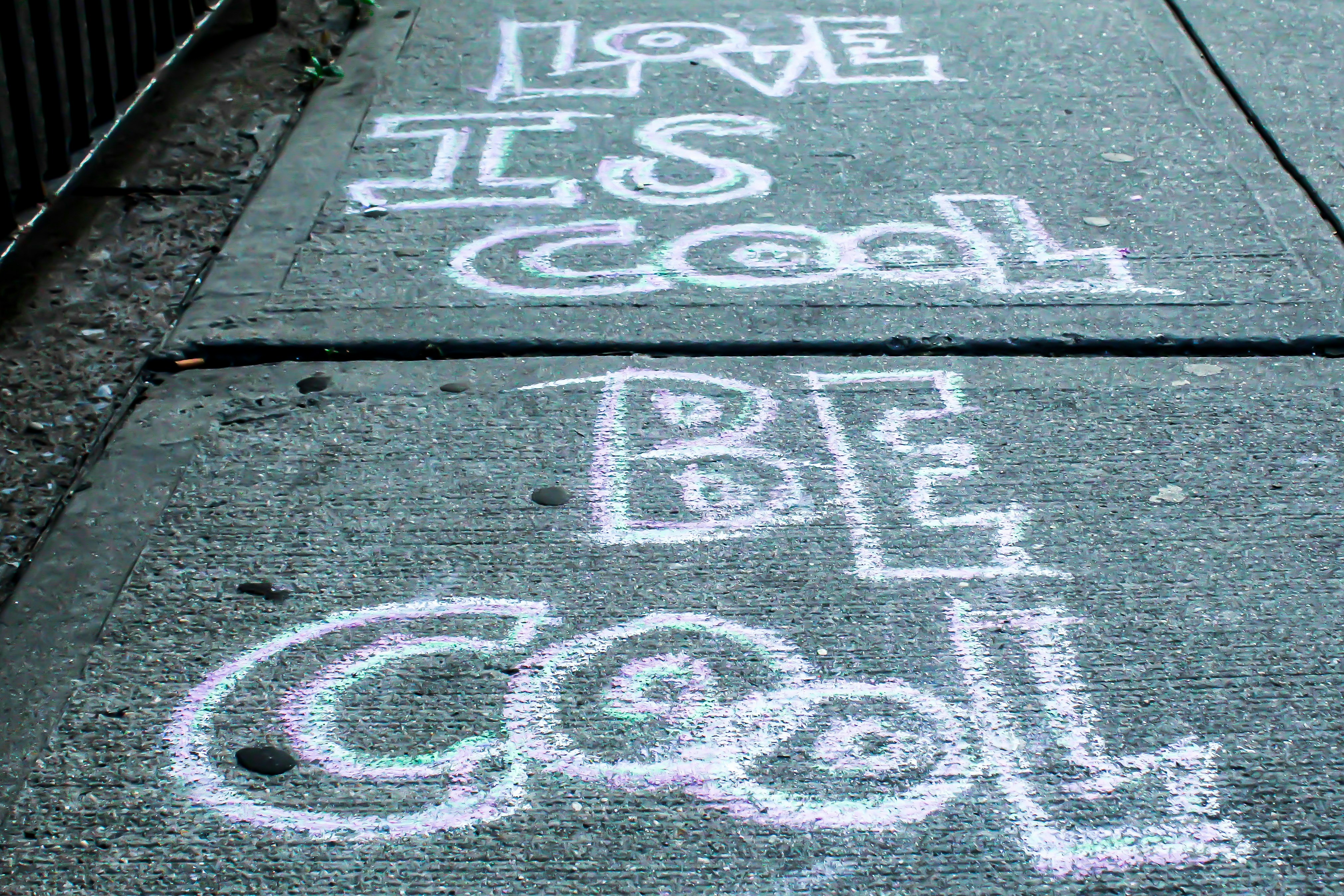 a sidewalk with chalk writing on it