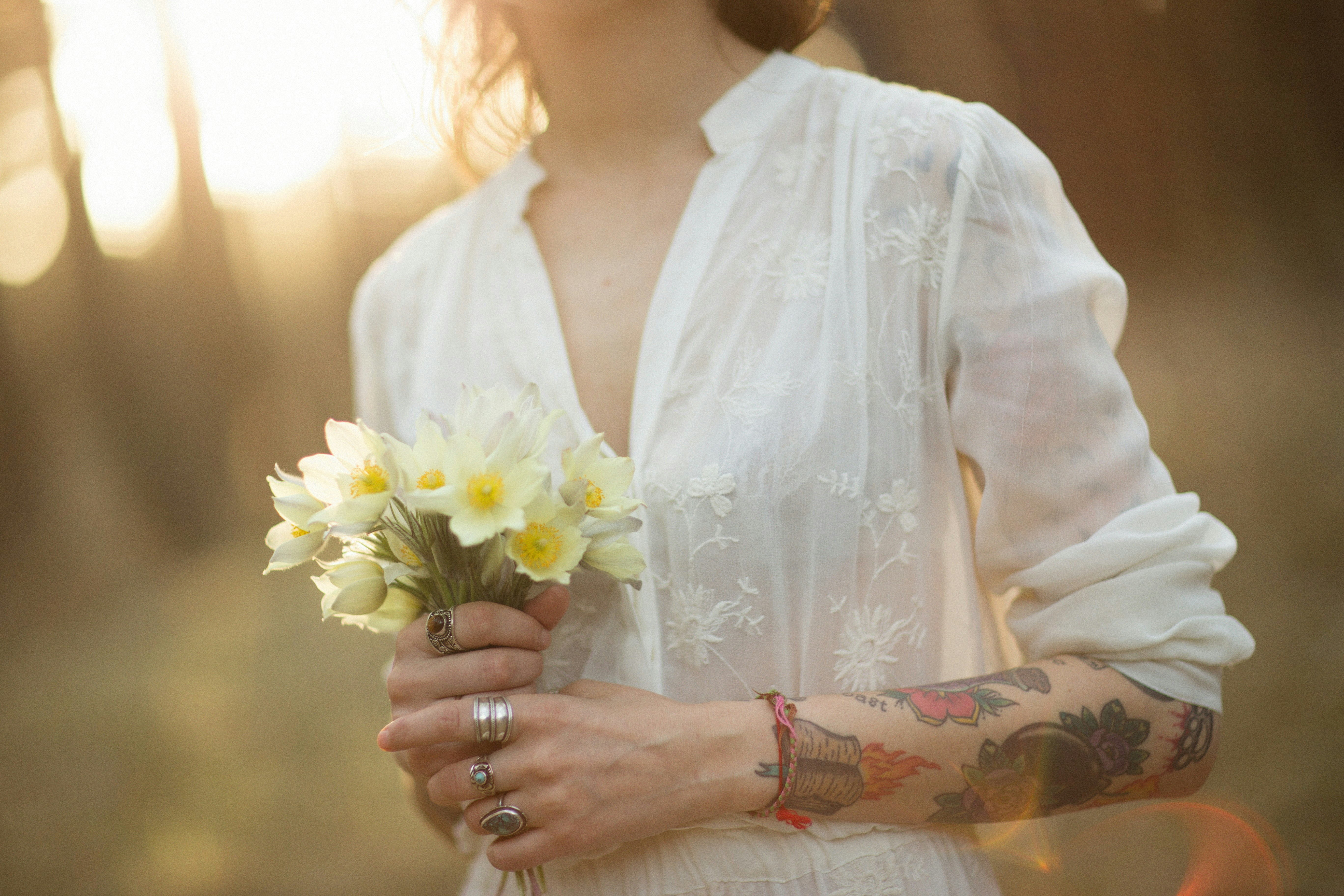 a woman in a white dress holding a bouquet of flowers