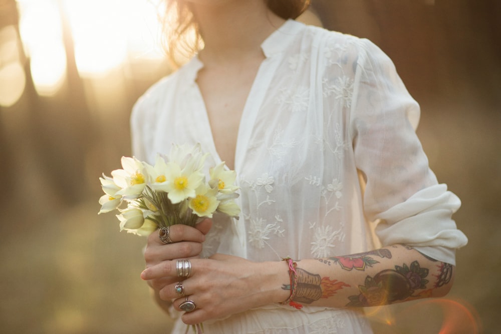 a woman in a white dress holding a bouquet of flowers