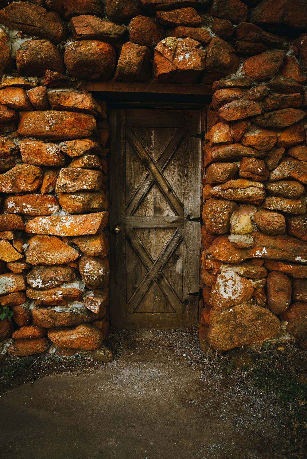 a wooden door sitting inside of a stone wall