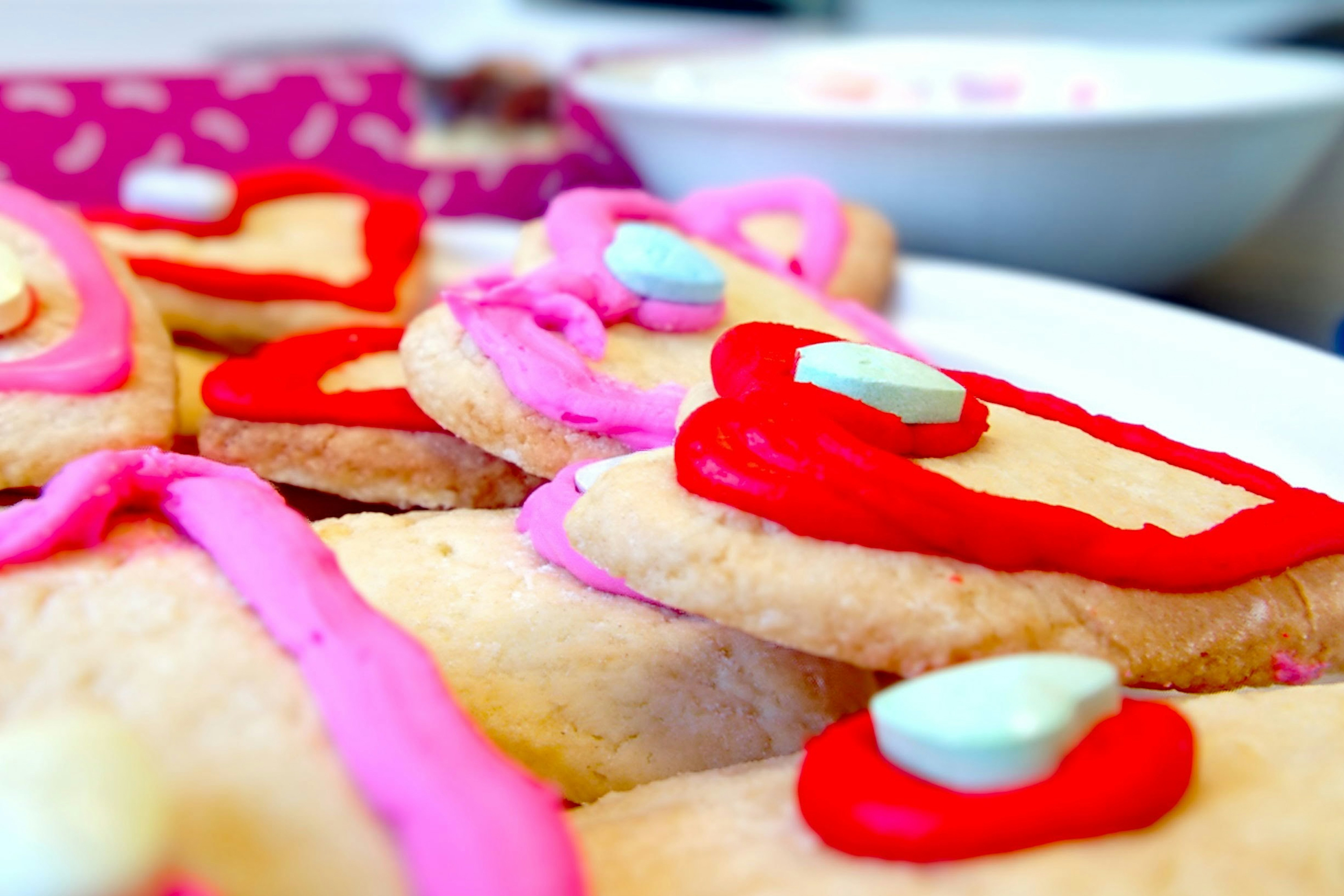 Frisch gebackene Herzplätzchen mit Zuckerguss – Symbol für Backen mit Liebe
