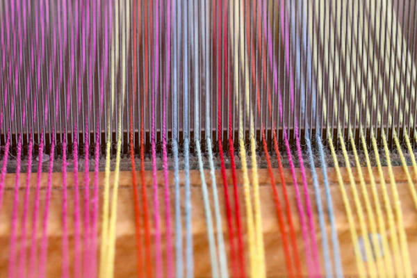 Close view of a weaving machine with yarn