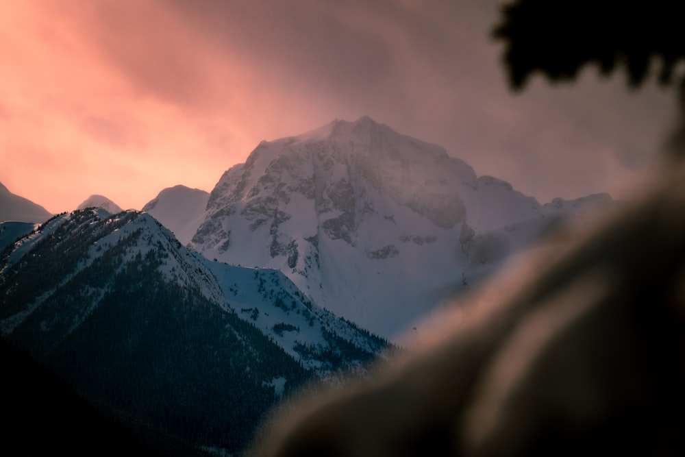 a view of a snow covered mountain at sunset