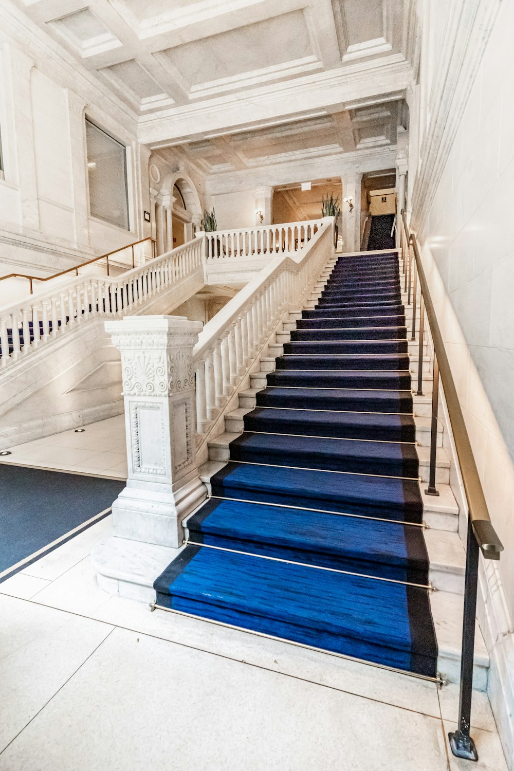 a blue carpeted staircase leading to a second story