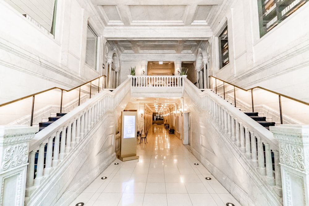 a large white building with a staircase leading up to the second floor